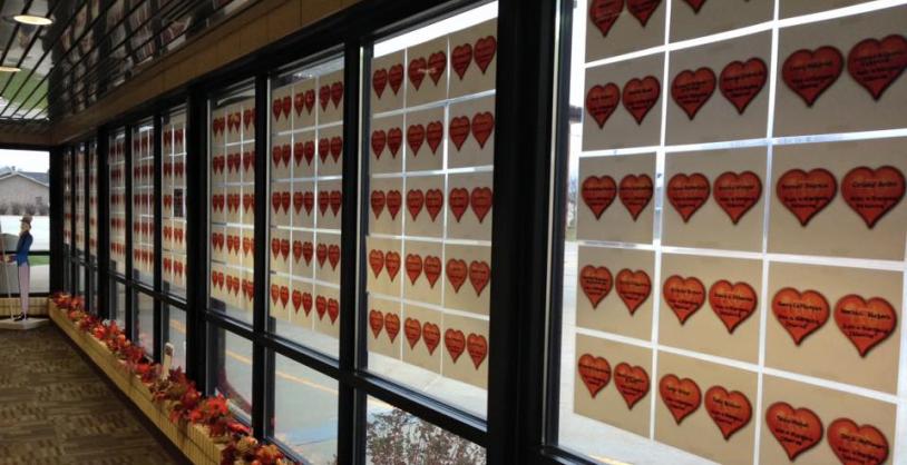 hallway window covered in paper with hearts with names written on them